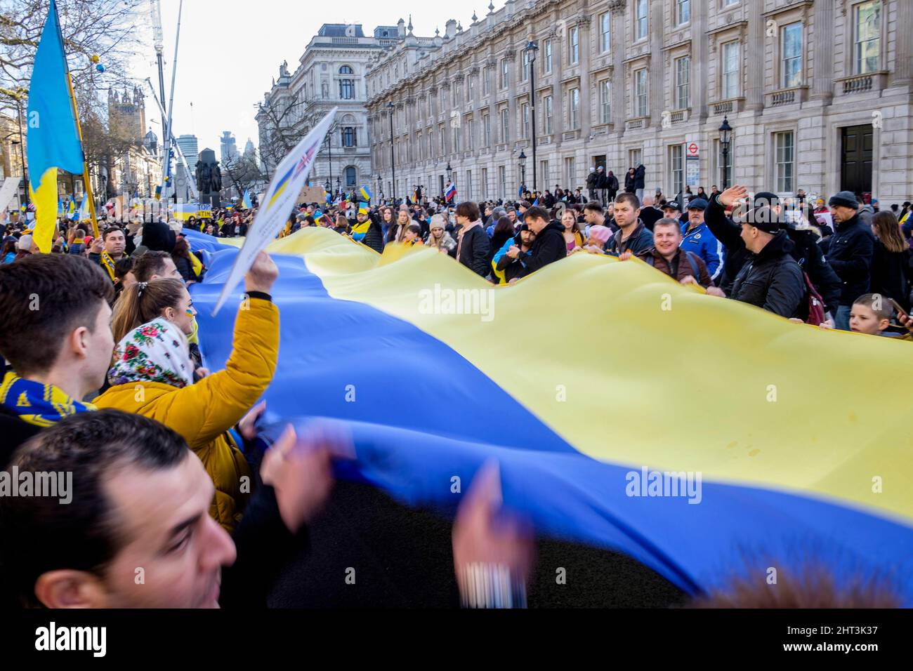 26th febbraio 2022: Cittadini ucraini e sostenitori pro-Ucraina si radunano a Whitehall per protestare contro l'invasione russa dell'Ucraina. Londra, Regno Unito. Nella foto: Un lungo banner nei colori della bandiera Ucraina viene srotolato e tenuto in alto alla manifestazione di Londra. Foto Stock