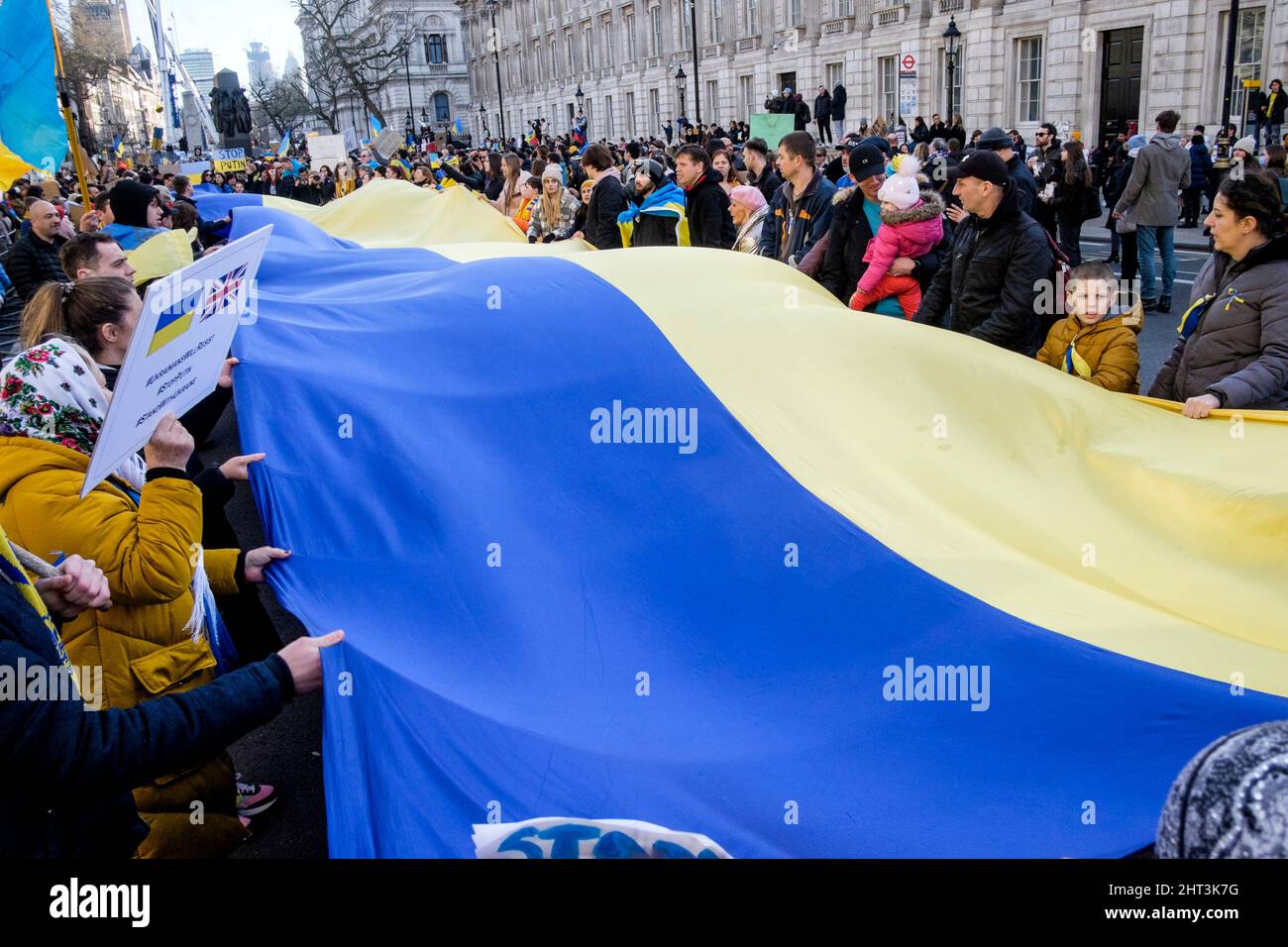 26th febbraio 2022: Cittadini ucraini e sostenitori pro-Ucraina si radunano a Whitehall per protestare contro l'invasione russa dell'Ucraina. Londra, Regno Unito. Nella foto: Un lungo banner nei colori della bandiera Ucraina viene srotolato e tenuto in alto alla manifestazione di Londra. Foto Stock