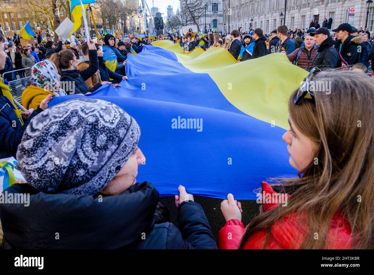 26th febbraio 2022: Cittadini ucraini e sostenitori pro-Ucraina si radunano a Whitehall per protestare contro l'invasione russa dell'Ucraina. Londra, Regno Unito. Nella foto: Un lungo banner nei colori della bandiera Ucraina viene srotolato e tenuto in alto alla manifestazione di Londra. Foto Stock