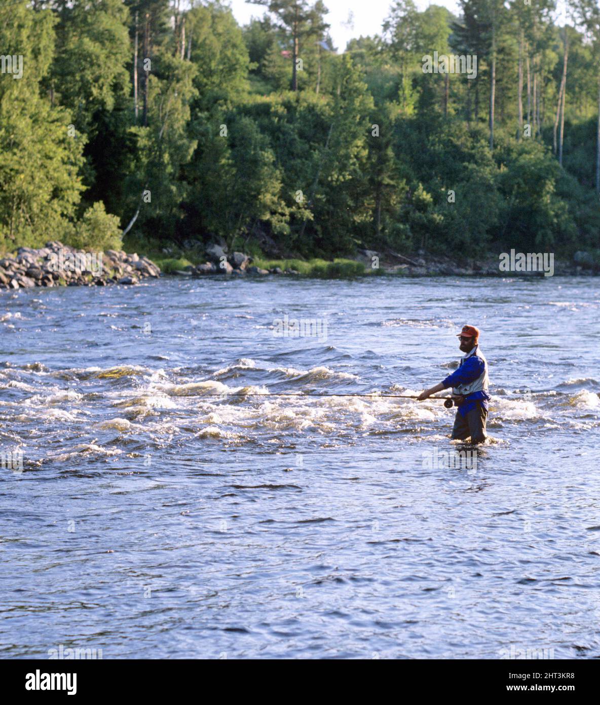 Uomo pesca a mosca nel fiume Foto Stock