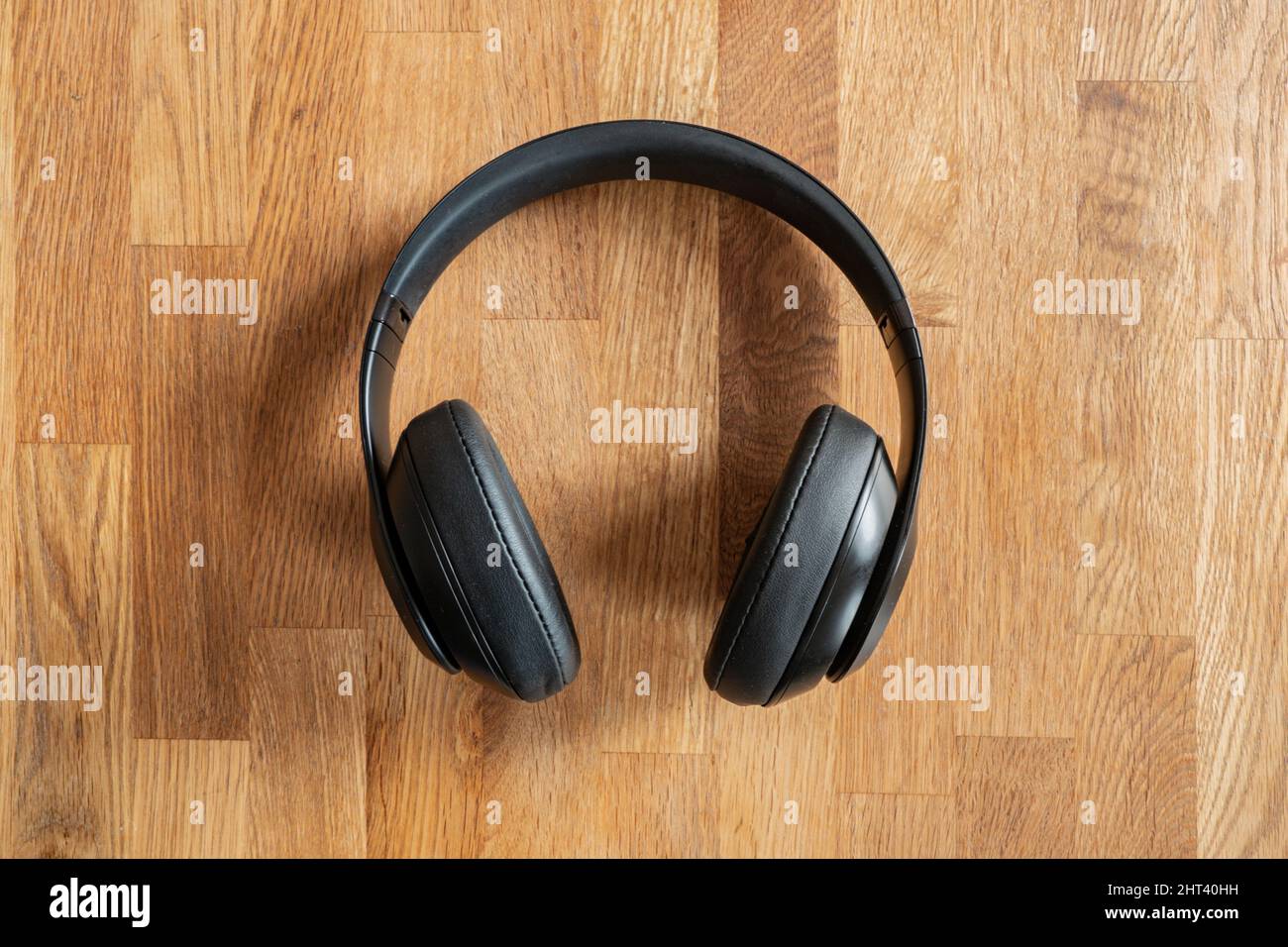 Vista dall'alto delle cuffie wireless nere su sfondo di legno Foto Stock