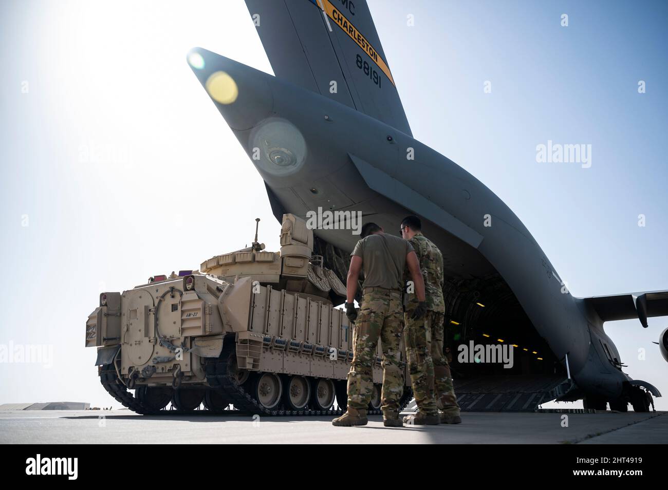 Stati Uniti Air Force staff Sgts. Phillip Noorlander, a sinistra, e Scott Ackerly, loadmasters assegnati al 816th Expeditionary Airlift Squadron, rivedere un piano di carico di un veicolo M2A3 Bradley Fighting fuori di un US Air Force C-17 Globemaster III alla Ali al Salem Air base, Kuwait, 1 febbraio 2022. Il C-17 è in grado di fornire rapidamente le truppe e tutti i tipi di carico alle basi operative principali o direttamente alle basi di avanzamento nell'area di responsabilità del comando centrale degli Stati Uniti. (STATI UNITI Air Force foto di staff Sgt. Joseph Pick) Foto Stock