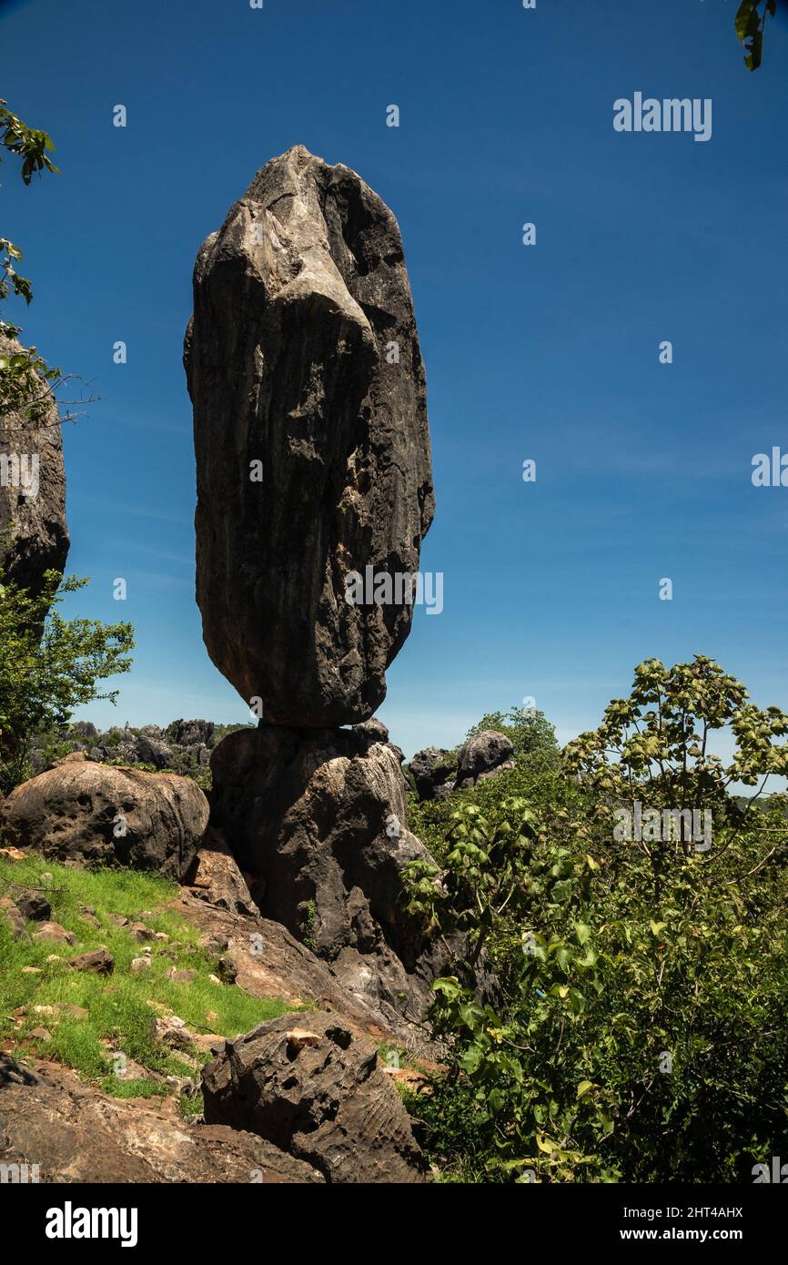 Un colpo verticale di un enorme roccia bilanciata su altre rocce di giorno. Foto Stock