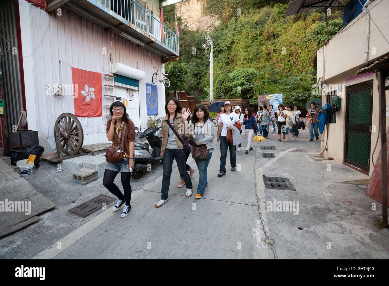 Gli adolescenti camminano attraverso un vicolo sull'isola di Cijin, il distretto di Cijin, Kaohsiung, Taiwan Foto Stock