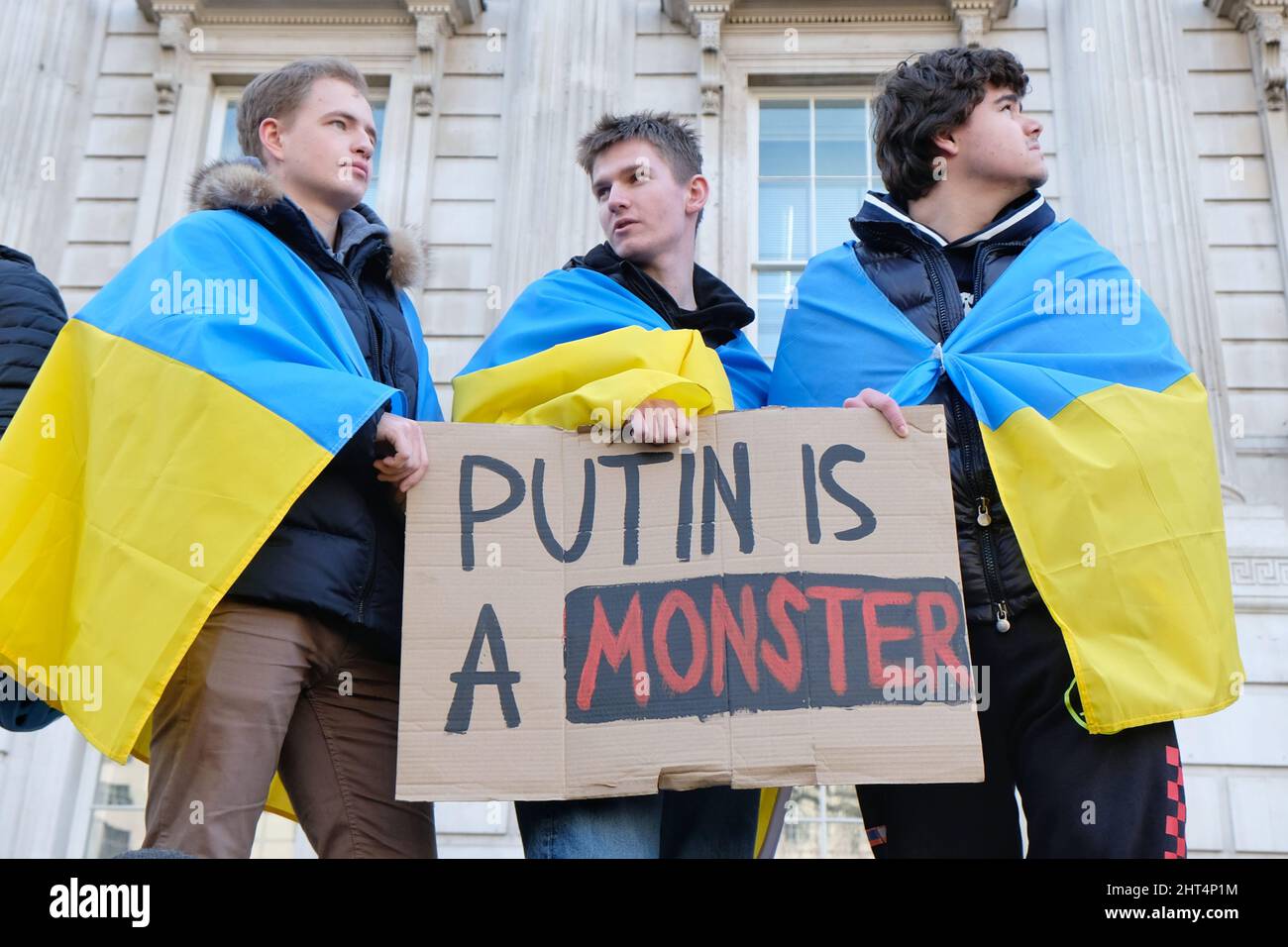 Londra (Regno Unito), 26th febbraio 2022, i manifestanti della guerra trascinati dalle bandiere ucraine facevano parte di centinaia di persone riunite lungo Whitehall in un raduno e in una manifestazione contro l'invasione del regime del presidente Vladamir Putin, chiedendo maggiori sanzioni economiche, Come il taglio dell'accesso al sistema di pagamento Swift da imporre alle banche russe. Credit: Undicesima ora Fotografia/Alamy Live News Foto Stock