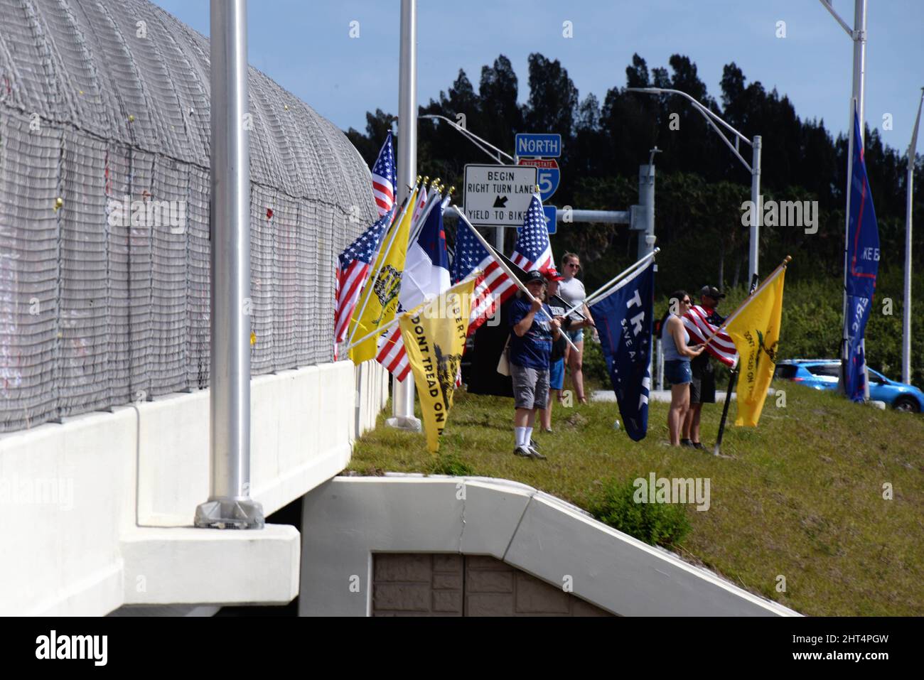 West Melbourne, Brevard County, Florida, Stati Uniti. Gruppo di bandiere che sventolano, segno che tiene, musica che suona sostenitori per il Florida Truckers Freedom Convoy diretto a Washington DC, assemblato su un ponte Interstate recintato i-95. La causa iniziale per il convoglio era sostenere i canadesi Truckers che protestano i mandati del coronavirus sul settore dei trasporti, tuttavia, questi mandati sono stati revocati recentemente. Photo Credit: Julian Leek/Alamy Live News Foto Stock