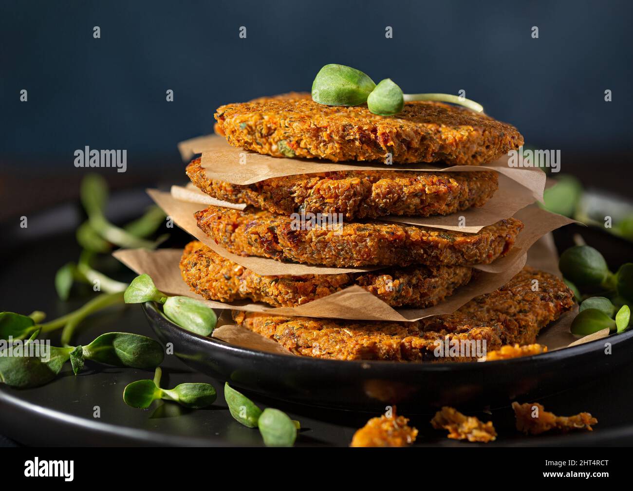 Impila di hamburger di quinoa di ceci appena fatti con micro girasole Foto Stock