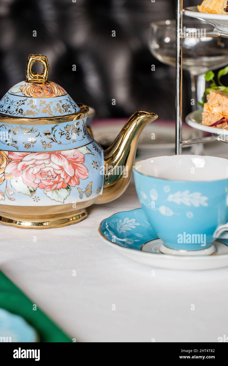 Primo piano della teiera floreale in porcellana e della tazza su un tavolo bianco Foto Stock