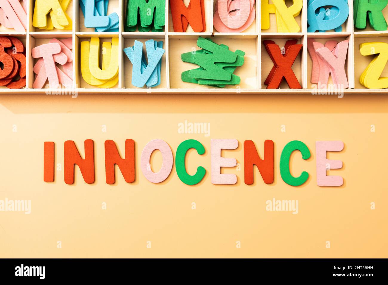 la parola innocenza rappresentata come un concetto da lettere di legno di colore su uno sfondo Foto Stock