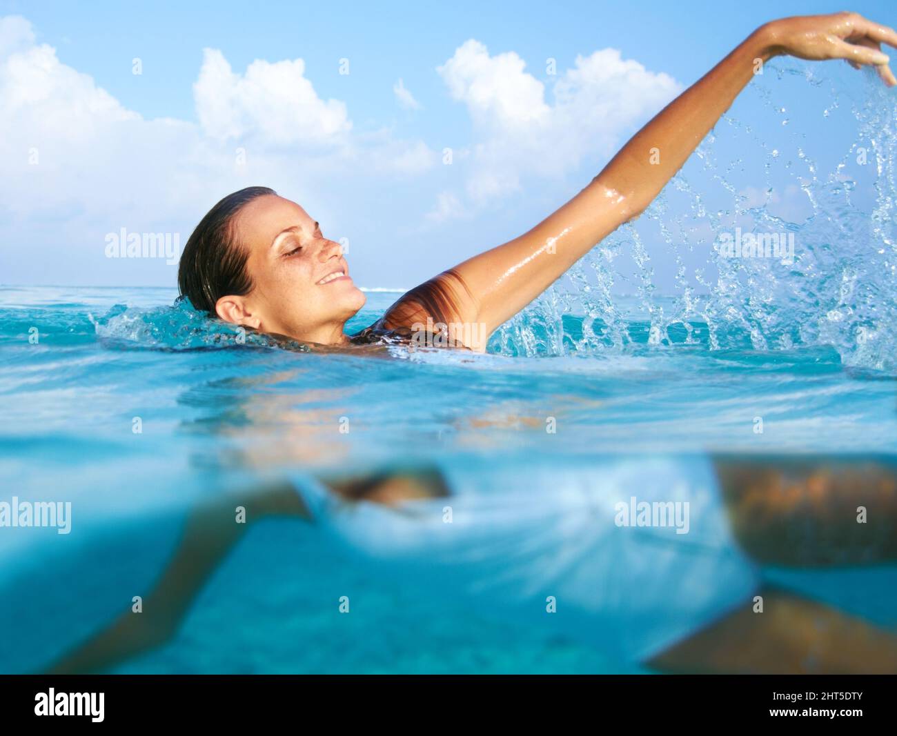 Divertimento nell'oceano. Scatto di una bella giovane donna che nuota nell'oceano blu. Foto Stock