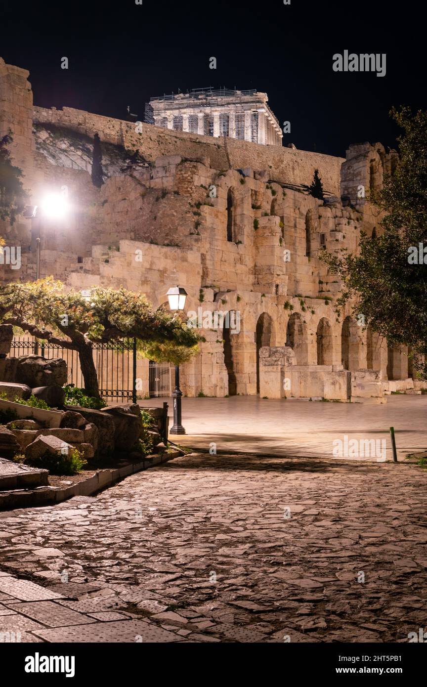 Vista ad angolo basso del Partenone di notte all'Acropoli di Atene, Grecia. Odeon di Erode Attico è visibile in primo piano Foto Stock