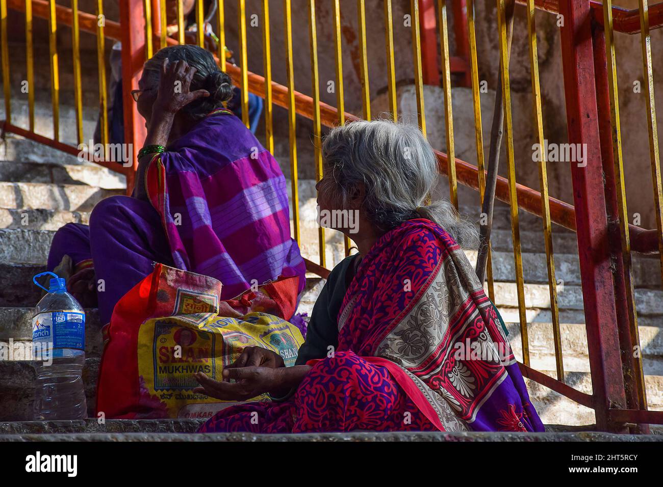 Donne indiane adulte appoggiate su recinzione metallica e vendere qualcosa. Foto Stock