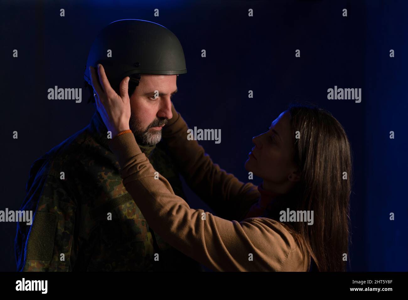 Una donna triste che dice addio al marito militare che sta per combattere in guerra. Foto Stock