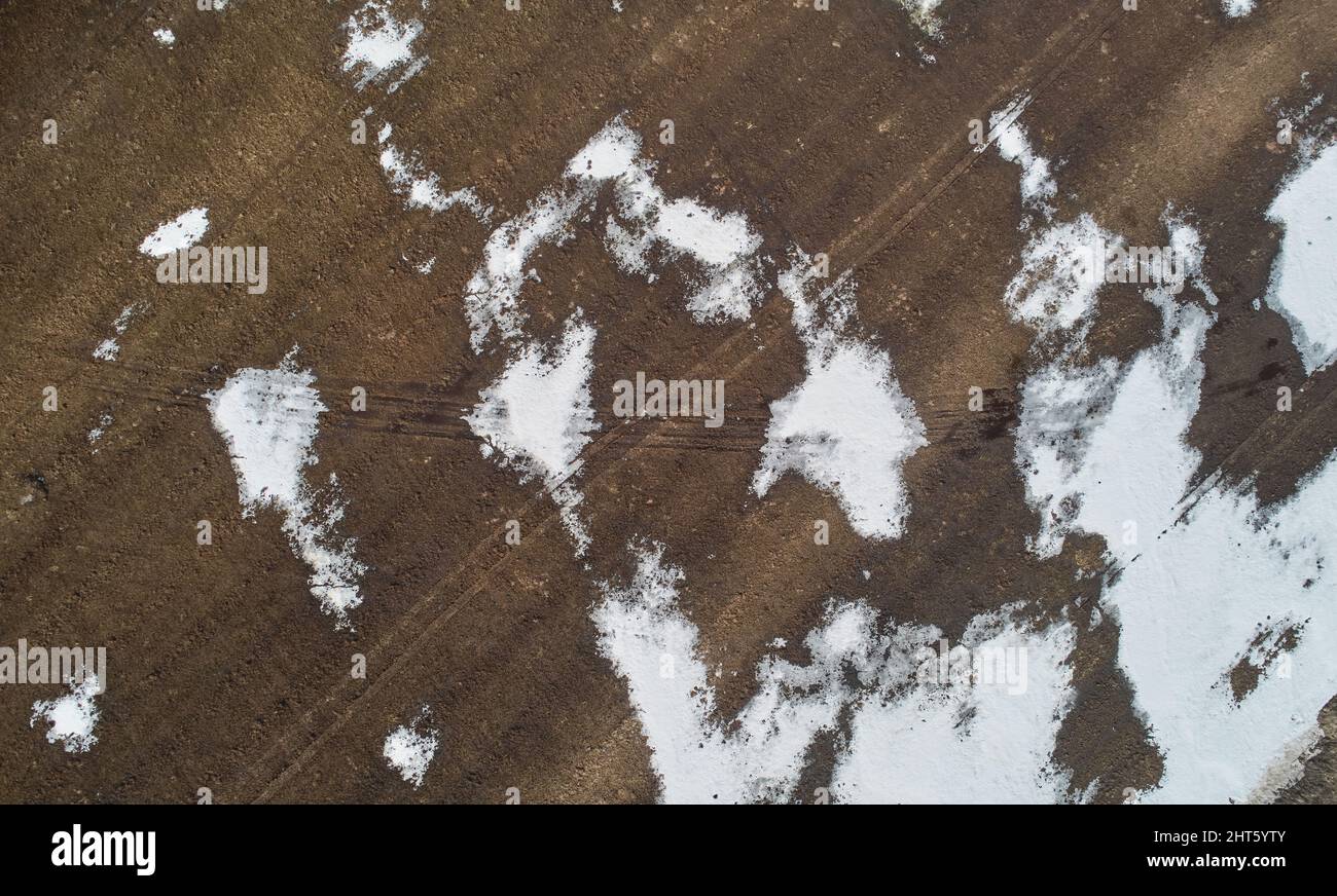 Sfondo paesaggio invernale. Terra marrone coperta con vista aerea neve Foto Stock