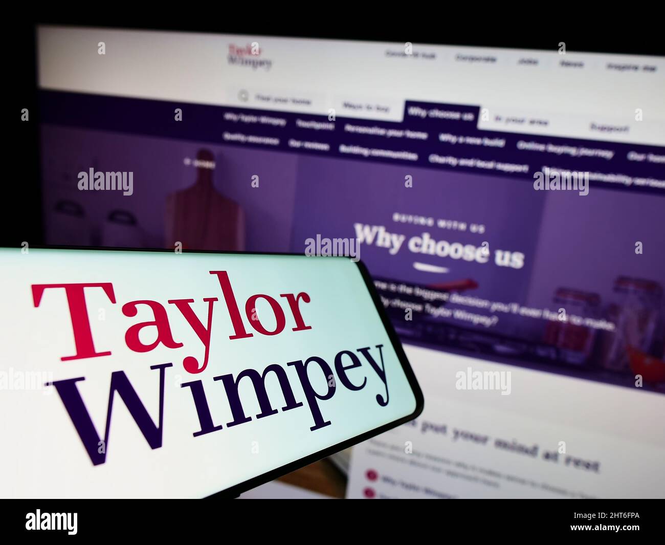 Smartphone con logo della casa britannica Taylor Wimpey plc sullo schermo di fronte al sito web. Concentratevi sul centro-destra del display del telefono. Foto Stock