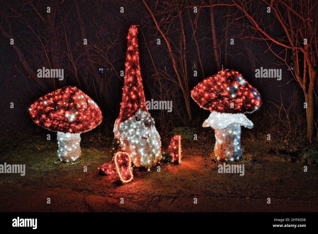Splendide figure magiche di funghi notturni con molte luci a LED che illuminano il giardino all'aperto Foto Stock