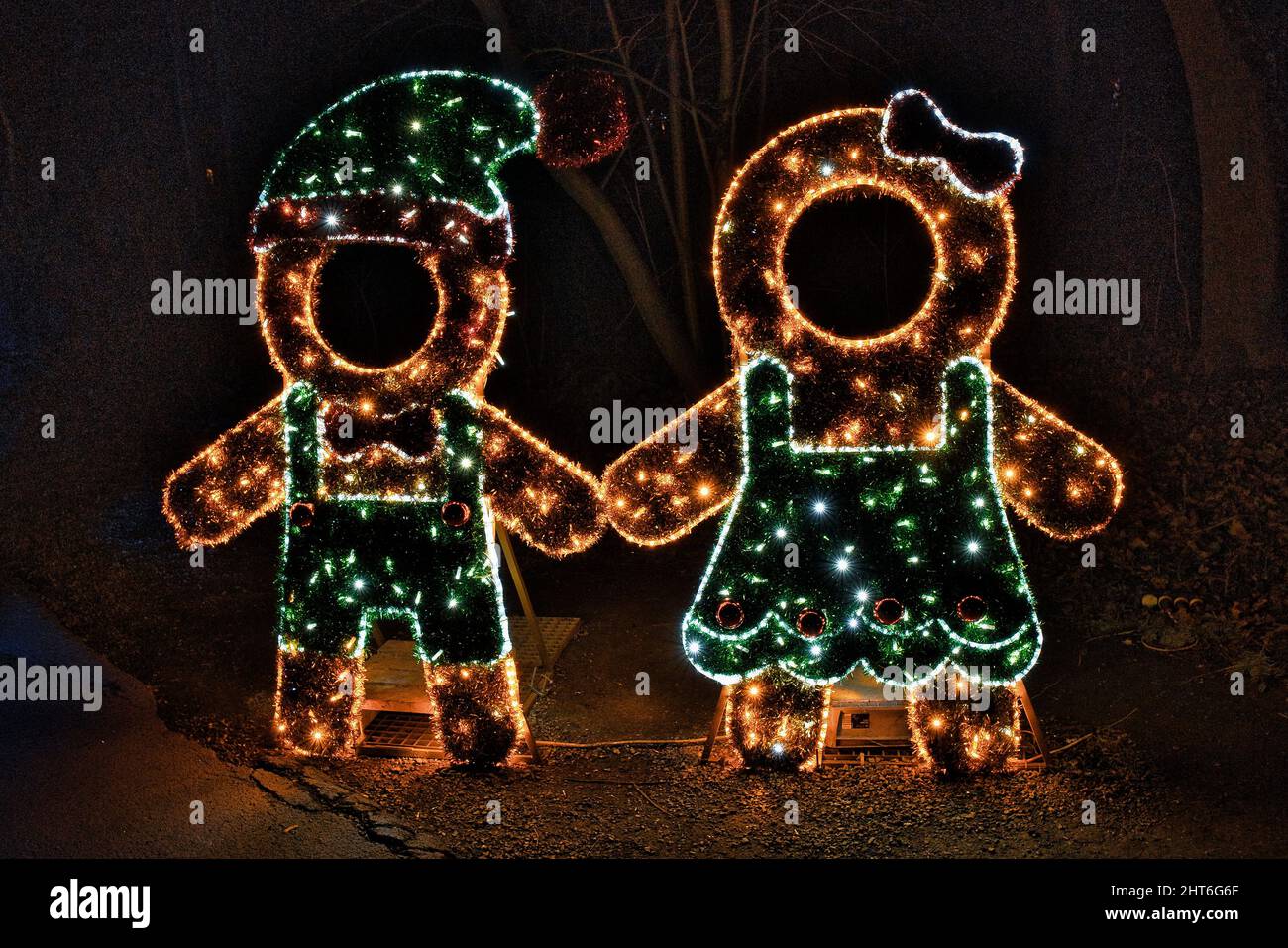 Splendida notte magica di due figure umane con molte luci a LED che illuminano nel giardino Foto Stock