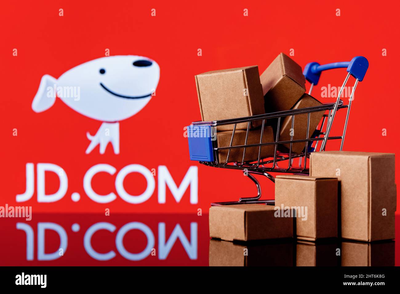JD.com è una società cinese di e-commerce. Carrello con pacchi sullo sfondo del logo JD.com. Foto Stock
