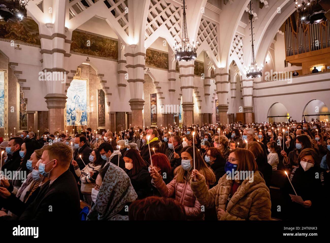 La gente tiene le candele che bruciano durante la veglia. Una veglia congiunta per il popolo ucraino si è svolta nella Chiesa di Senhora da Conceição in Piazza Marquês, a Porto, organizzata dalla Parrocchia Ortodossa Ucraina di San Pantaleon e dalla Parrocchia Cattolica di Senhora da Conceição. Foto Stock