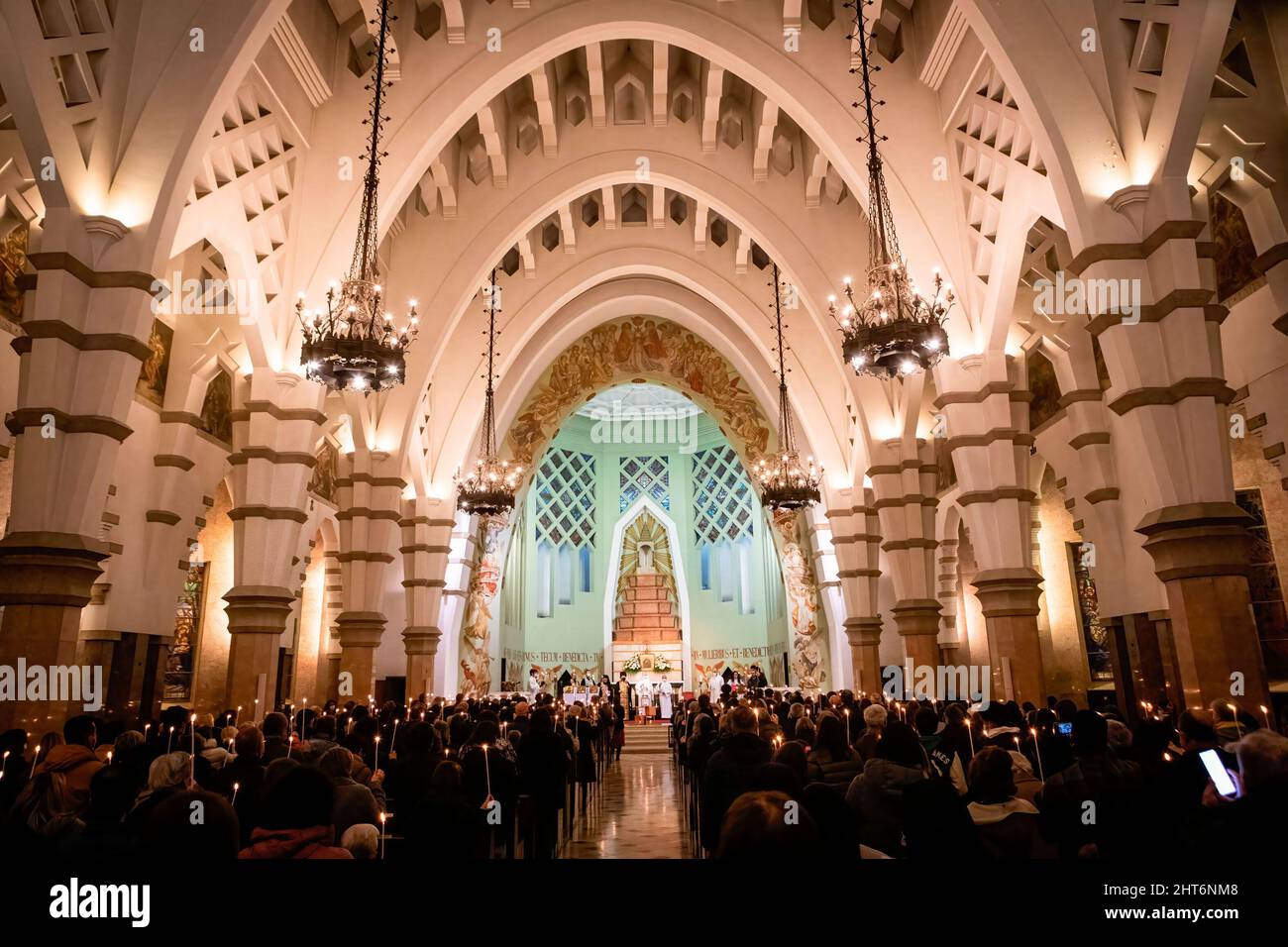 La gente tiene le candele che bruciano durante la veglia. Una veglia congiunta per il popolo ucraino si è svolta nella Chiesa di Senhora da Conceição in Piazza Marquês, a Porto, organizzata dalla Parrocchia Ortodossa Ucraina di San Pantaleon e dalla Parrocchia Cattolica di Senhora da Conceição. Foto Stock