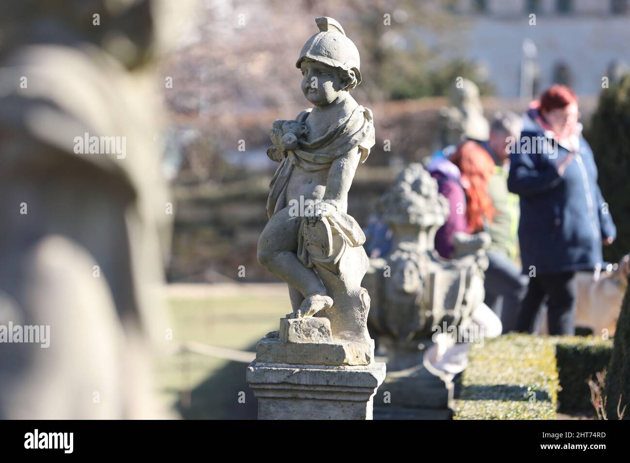 Blankenburg, Germania. 27th Feb 2022. I visitatori camminano nel giardino con terrazza barocca sotto il grande castello di Blankenburg nel parco e godersi il sole. L'area ben tenuta è disposta su quattro livelli e presenta dodici sculture in arenaria che simboleggiano i segni dello zodiaco. Il giardino terrazzato è uno dei 12 giardini più belli dello stato di Sassonia-Anhalt. Come giardino di piacere principesco, questo parco è stato costruito intorno al 1725. Credit: dpa/dpa-Zentralbild/dpa/Alamy Live News Foto Stock