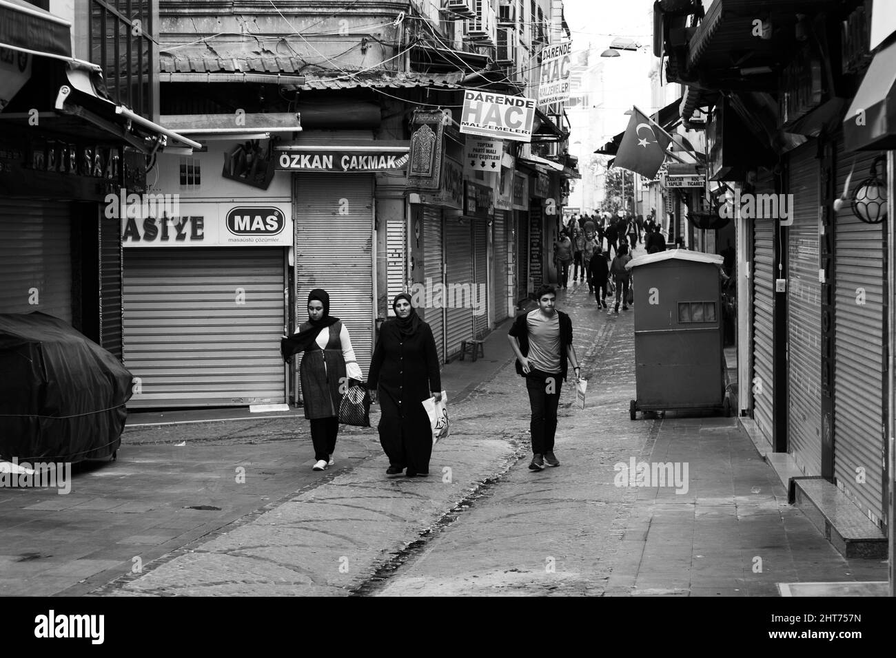 Foto di strada in scala di grigi della madre e dei suoi figli che camminano in una strada di Istanbul, Turchia. Foto Stock