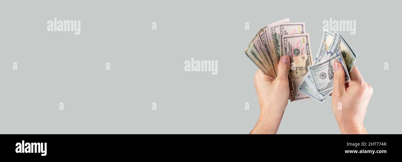Banner con mani contando bollette in dollari USA su sfondo grigio. Concetto di calcolo dei ricavi e dei costi. CopySpace. Foto di alta qualità Foto Stock