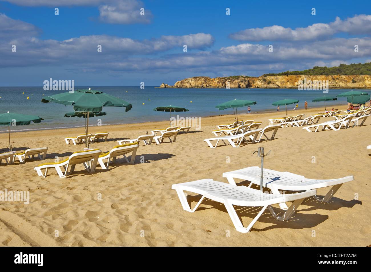 Scogliera dorata con ombrellone e solarium sulla spiaggia di Praia do Vau a Portimao, Algarve, Portogallo Foto Stock