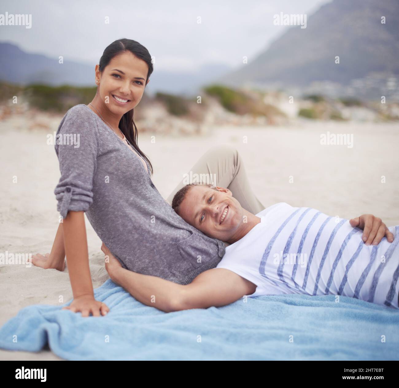 Io e il mio bambino sulla spiaggia. Scatto di un bel giovane uomo sdraiato sul suo giro di fidanzate alla spiaggia. Foto Stock