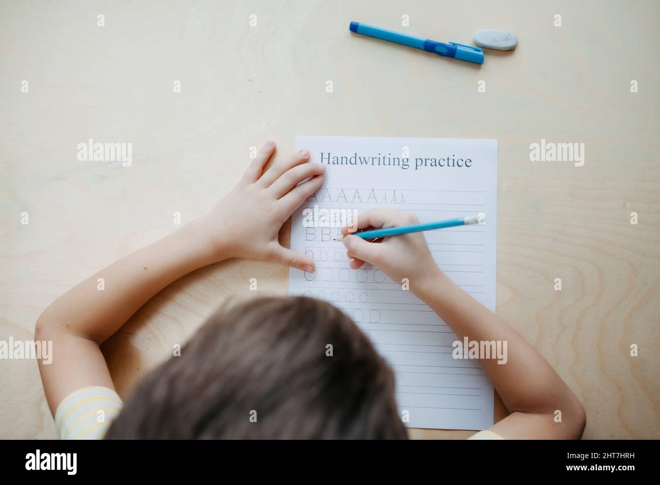 Uno scolaro che fa una lezione di matematica seduto alla scrivania nella stanza dei bambini Foto Stock