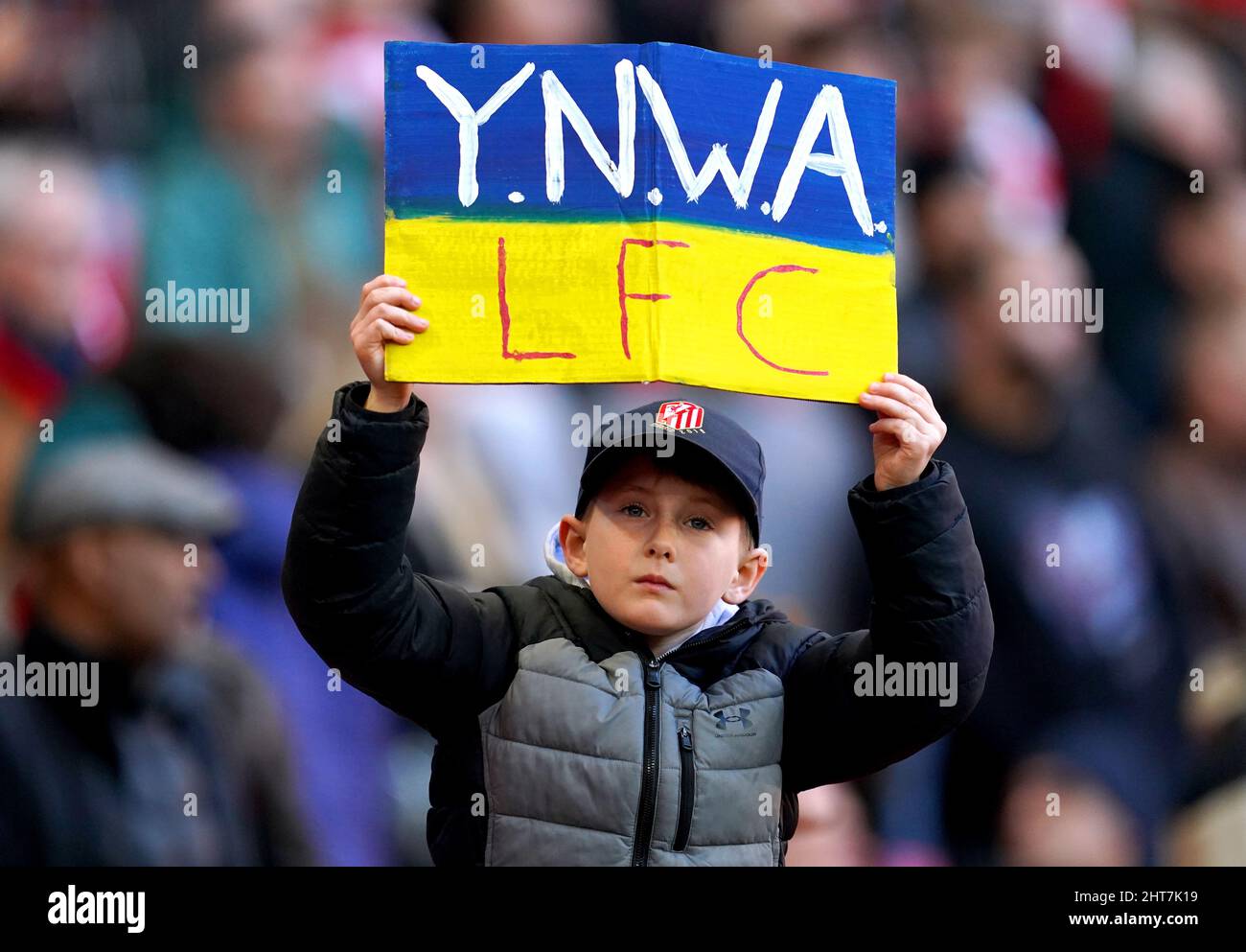 Un giovane fan di Liverpool ha un cartello "non camminerai mai da solo" nei colori della bandiera Ucraina davanti alla finale della Carabao Cup al Wembley Stadium di Londra. Data foto: Domenica 27th febbraio, 2022. Foto Stock