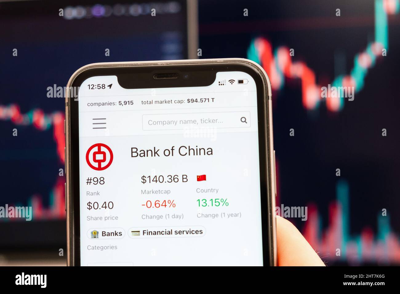 Bank of China stock price on the screen of cell phone in mans hand with changing stock market Exchange with trading candlestick graph analysis, febbraio 2022, San Francisco, USA Foto Stock