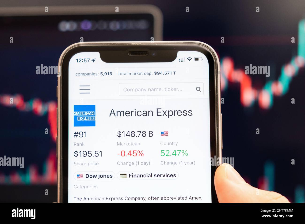 American Express stock price on the screen of cell phone in mans hand with changing stock market Exchange with trading candlestick graph analysis, febbraio 2022, San Francisco, USA Foto Stock