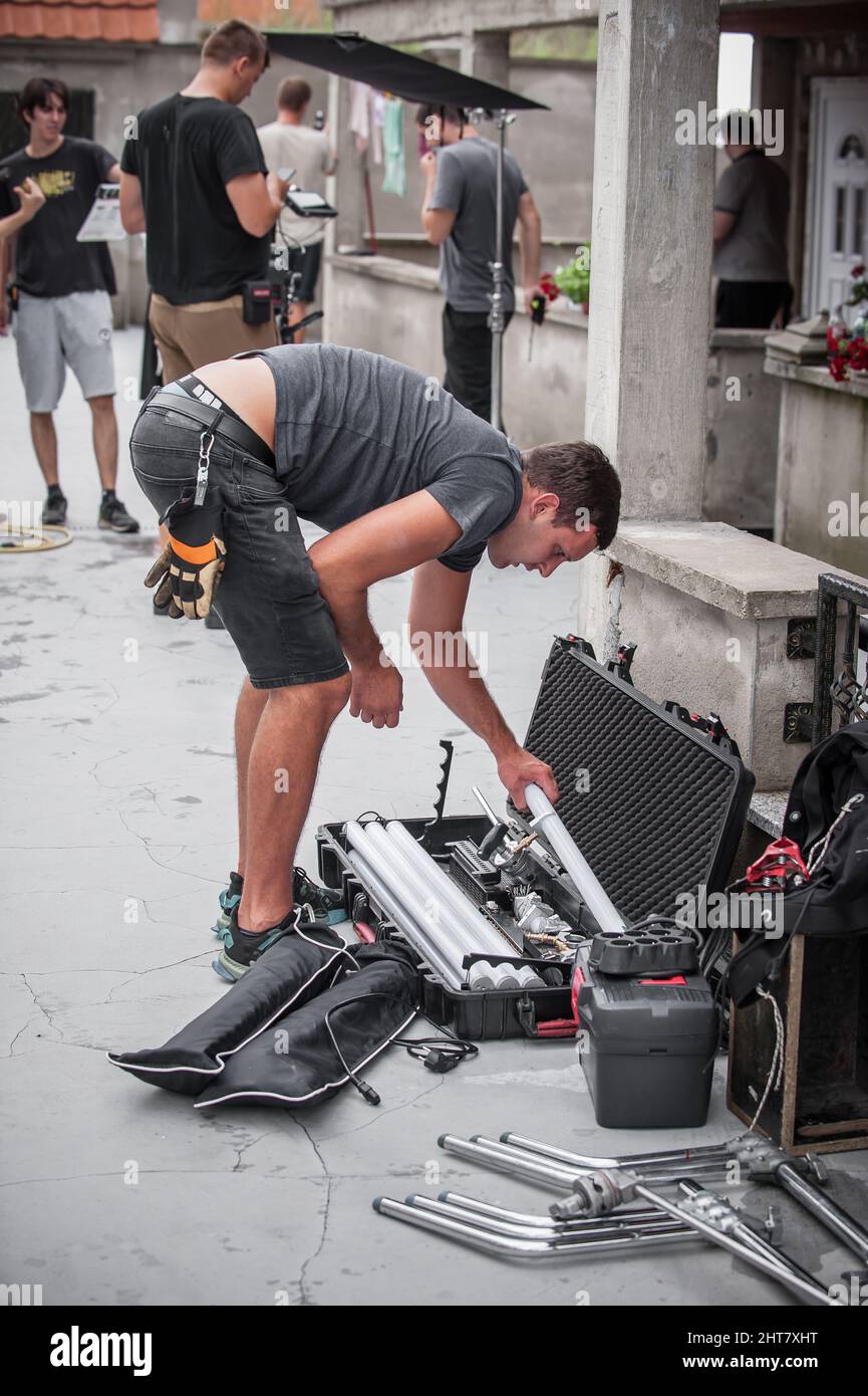 Dietro la scena. Tecnico di illuminazione filmmaking ingegnere elettrico regolazione e impostazione luci per la scena di film. Reparto luce. Film Crew. (Equipaggio pellicola Foto Stock
