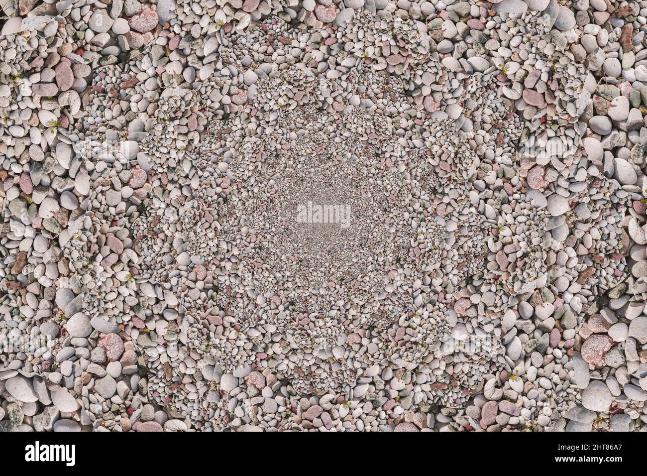 Mucchio di ciottoli messi in un modello frattale rotondo, gradualmente zoomando verso il basso nel mezzo Foto Stock