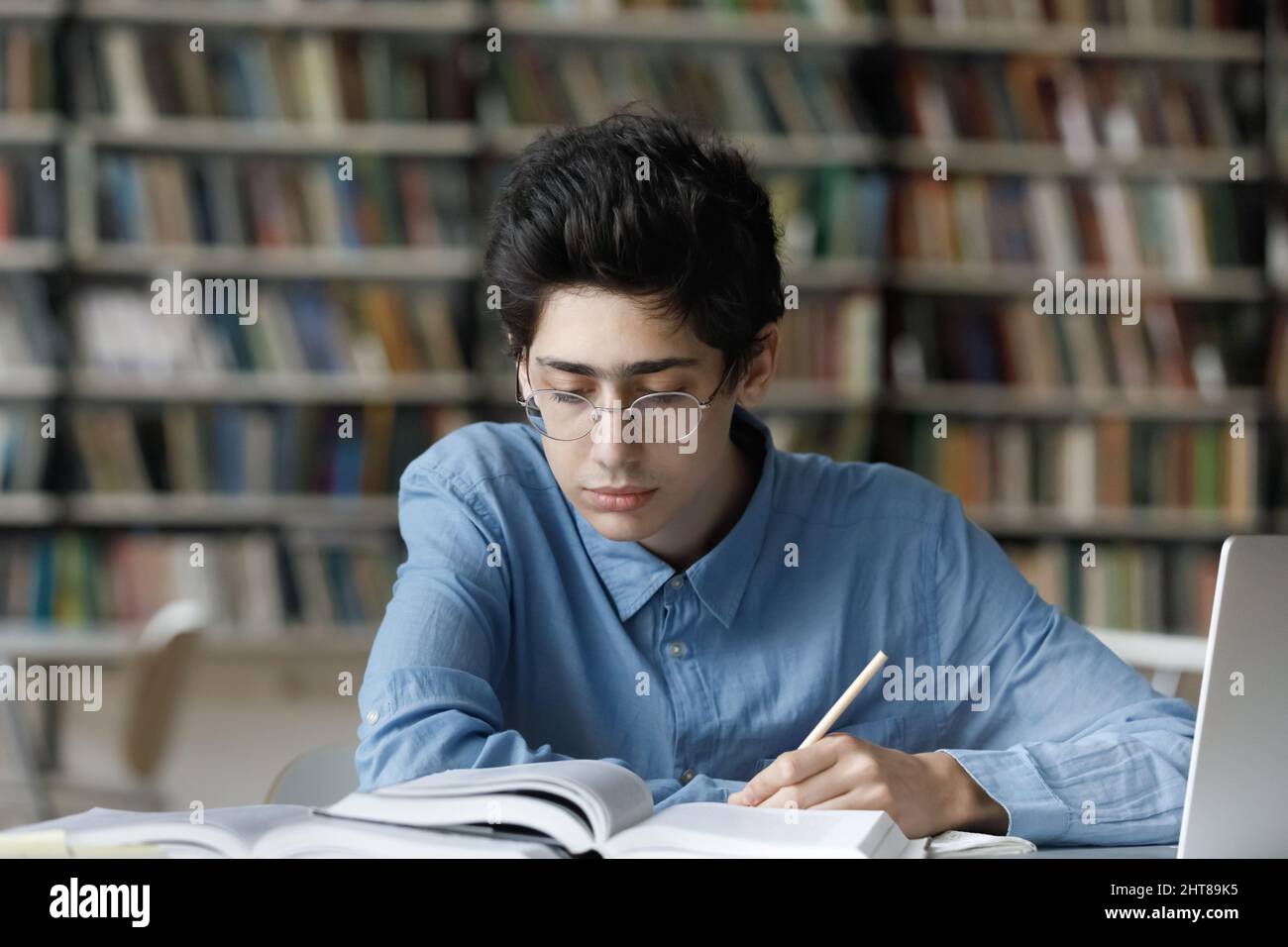 Concentrato giovane studente ebraico maschile impegnato che studia in biblioteca. Foto Stock