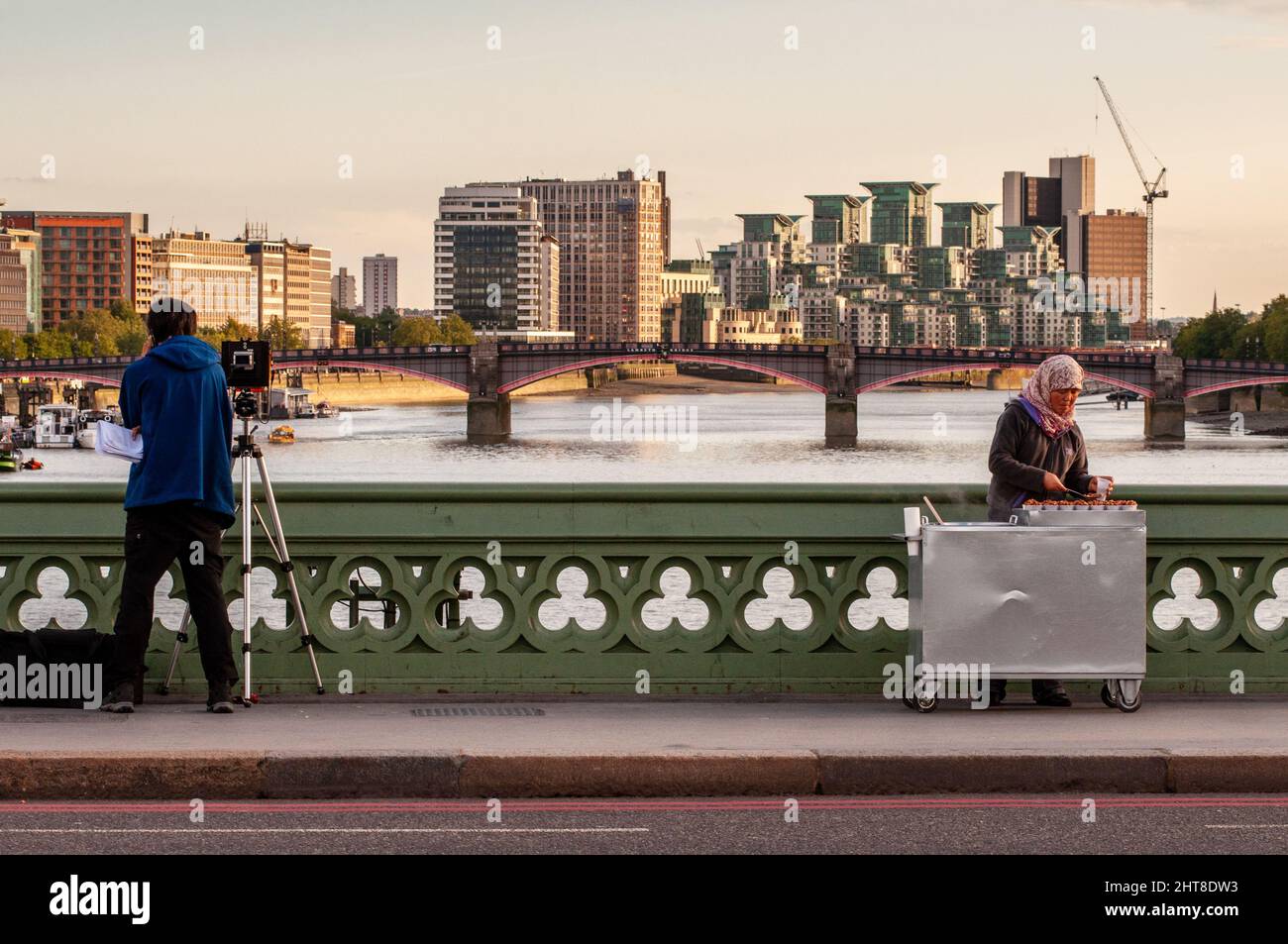 Londra, Inghilterra, Regno Unito - 18 settembre 2010: Un giornalista televisivo e un venditore di Street food stand sul marciapiede del Westminster Bridge nel centro di Londo Foto Stock