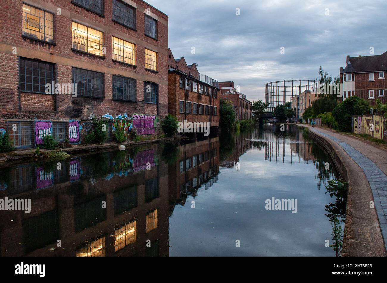 Gli edifici di fabbriche, magazzini e appartamenti fieggiano il canale del Regent nell'East End di Londra. Foto Stock