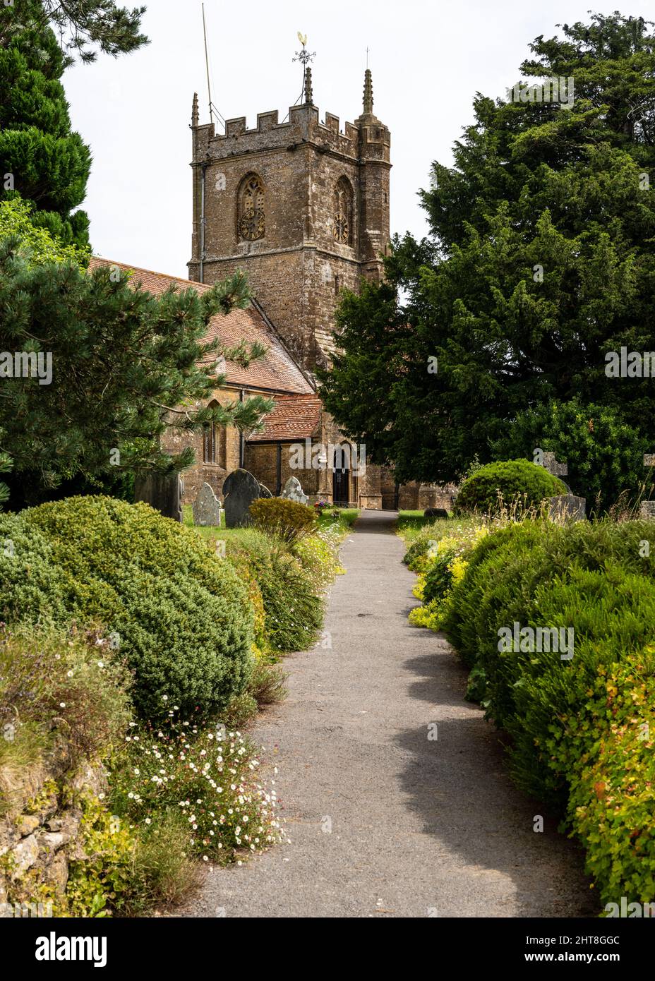 Un sentiero conduce attraverso il sagrato della tradizionale chiesa parrocchiale di San Pietro e San Paolo a Odcombe, Somerset. Foto Stock