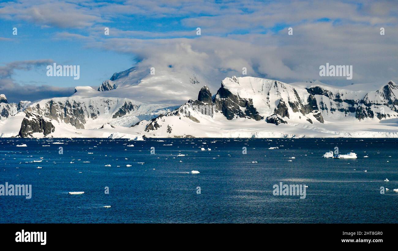 Una vista panoramica dell'Arcipelago di Palmer nello stretto di Gerlache in Antartide sotto un cielo blu nuvoloso Foto Stock