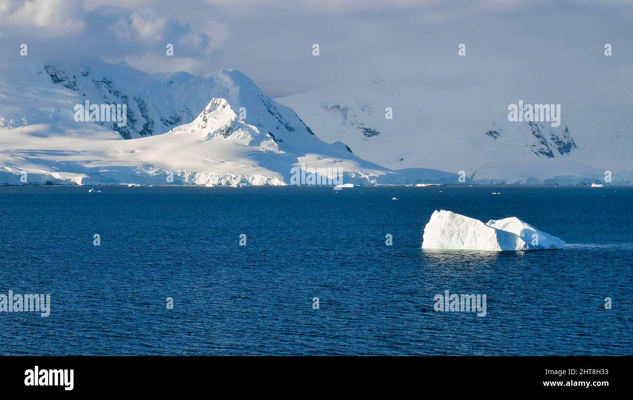 Una vista panoramica dell'Arcipelago di Palmer coperto da rocce ghiacciate in Antartide sotto un cielo blu nuvoloso Foto Stock