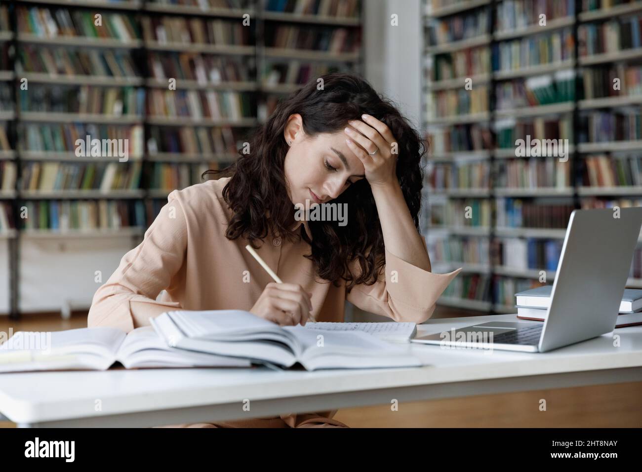 Infelice stressò la giovane ispanica che si sentiva stanca studiando in biblioteca. Foto Stock