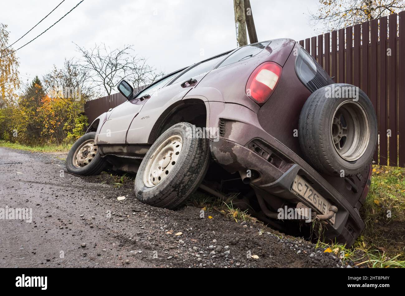 Leningrad Oblast, Russia - 19 ottobre 2019: Chevrolet Niva auto in un incidente si trova in un fossato da strada rurale di giorno, vista posteriore Foto Stock