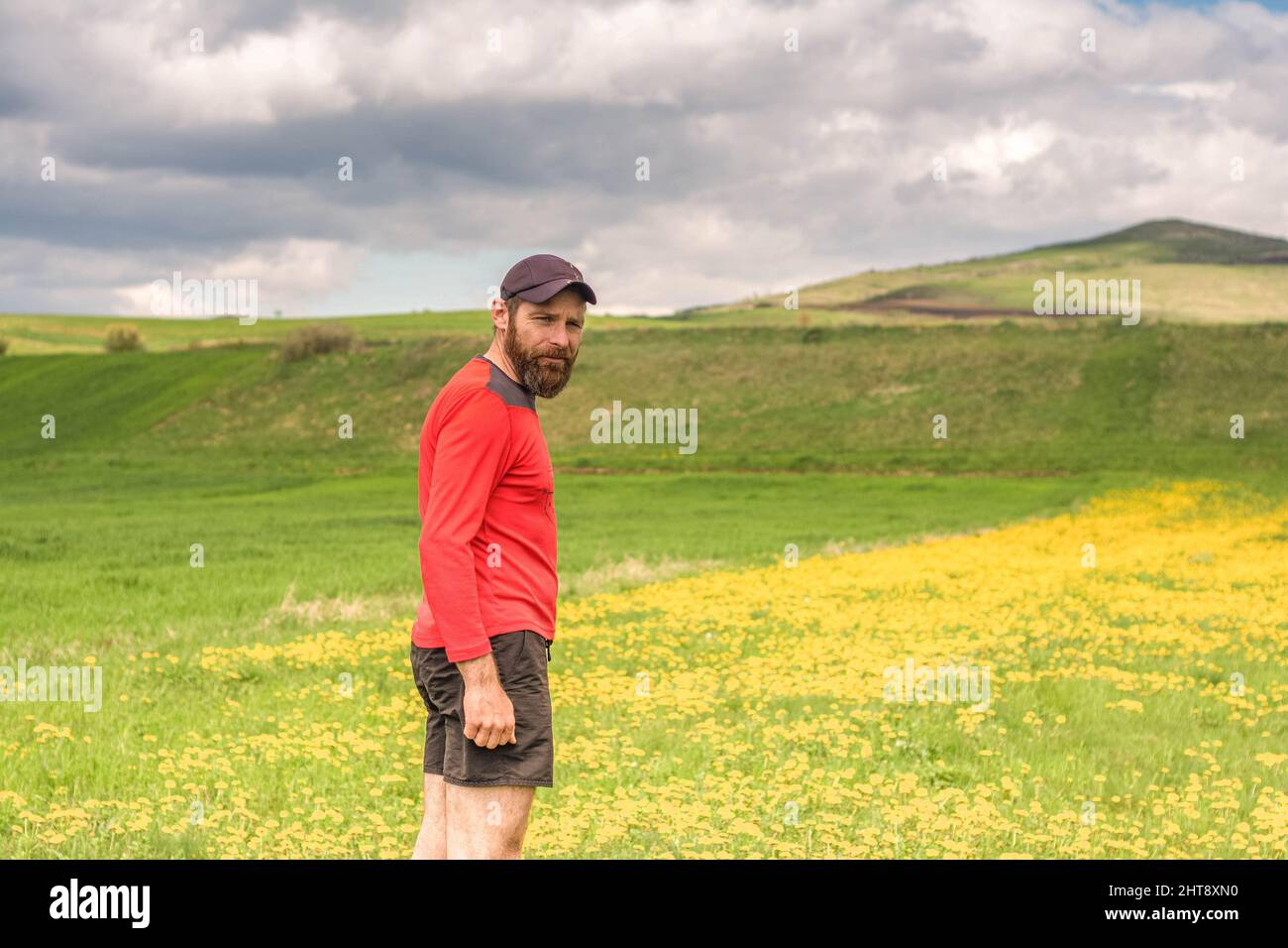 Montare un atleta maschio si sta preparando per un lavoro in natura mentre cerca su una scogliera sul grande lago e montagna linea. Foto Stock