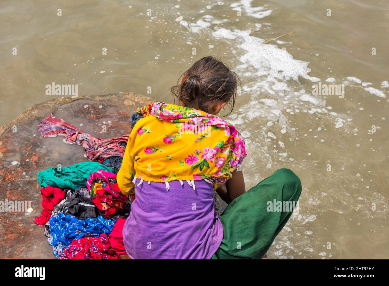 Donna lavaggio lavanderia sulla riva del fiume Ganges, Kolkata, West Bengala, India Foto Stock