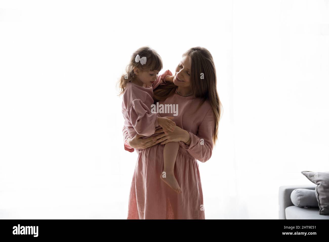 Felice mamma incinta che tiene la bambina più anziana in braccio Foto Stock