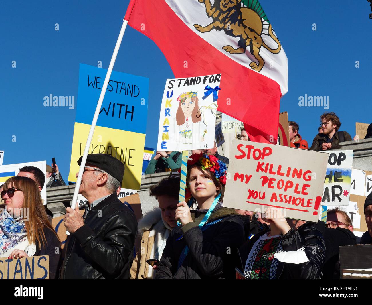 Vista dei manifestanti riuniti a Trafalgar Square Londra che sventolano bandiere, striscioni e cartelli per protestare contro l'invasione russa dell'Ucraina Foto Stock