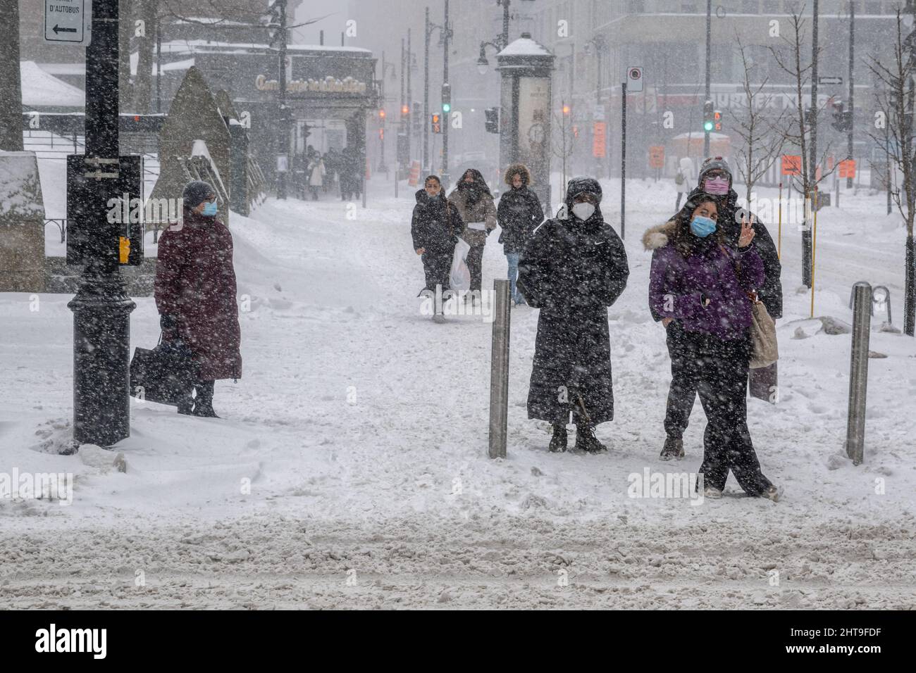 Montreal, CA - 25 Febbraio 2022: Pedoni che camminano nel centro di Montreal durante la tempesta di neve. Foto Stock