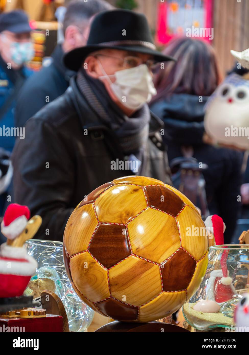 Colmar, Francia - 13 dicembre 2021: Modello in legno di una palla e di un uomo con la maschera igienica alla fiera di Colmar Foto Stock