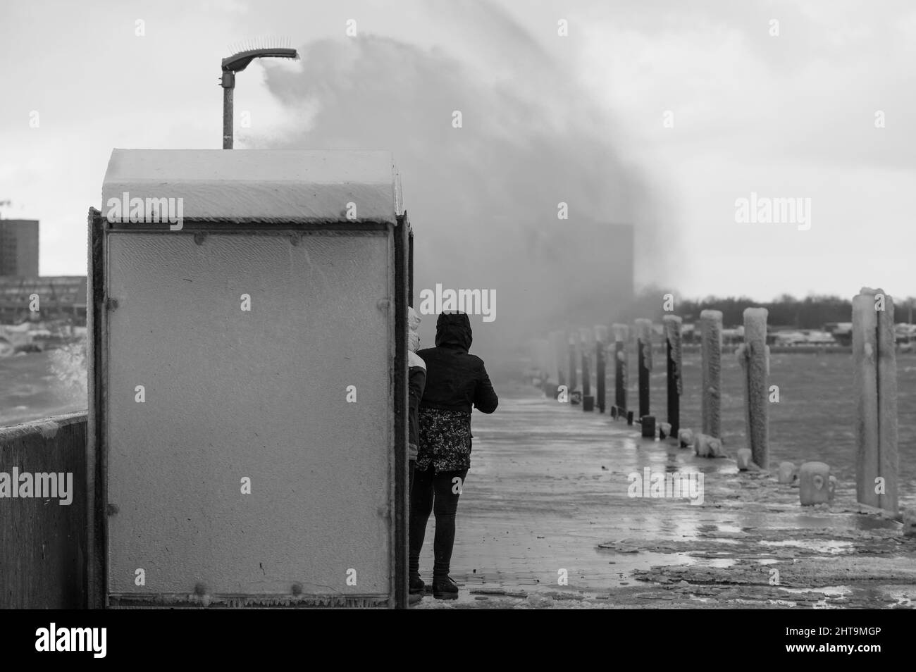 Vista di due ragazze sul molo durante una tempesta invernale Foto Stock